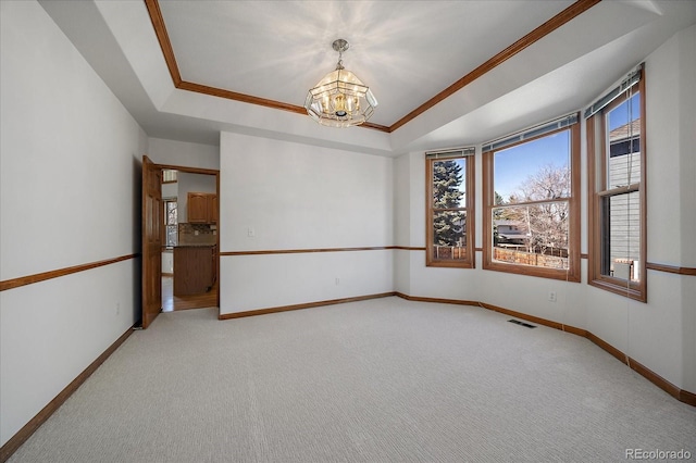 spare room featuring light carpet, baseboards, visible vents, a tray ceiling, and a chandelier