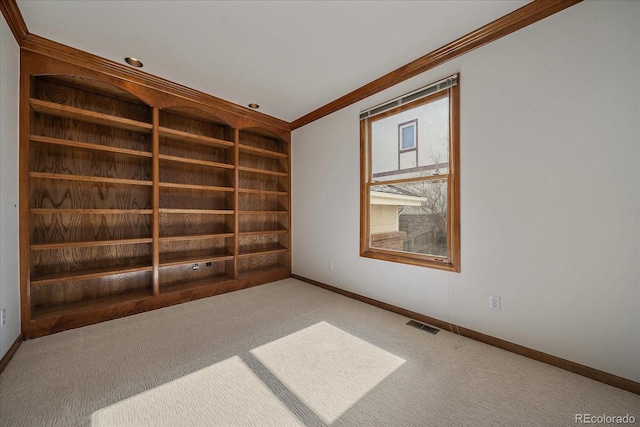 carpeted empty room featuring ornamental molding, visible vents, and baseboards