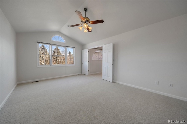 unfurnished bedroom with light carpet, baseboards, and vaulted ceiling