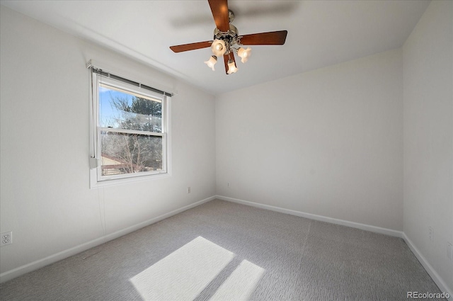 carpeted empty room featuring a ceiling fan and baseboards