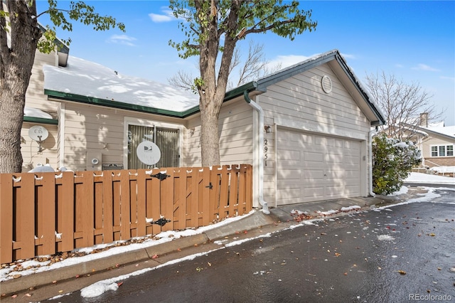 snow covered property featuring a garage