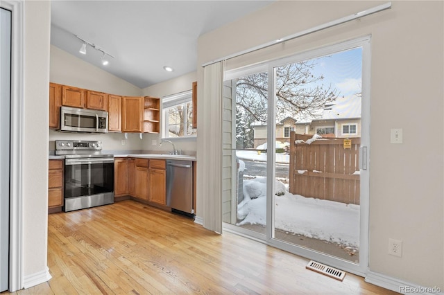 kitchen featuring lofted ceiling, light wood-type flooring, and appliances with stainless steel finishes