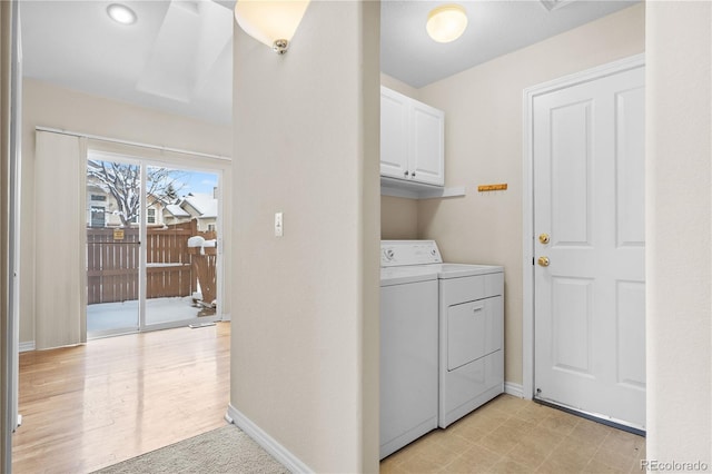 laundry area with light wood-type flooring, cabinets, and washing machine and clothes dryer