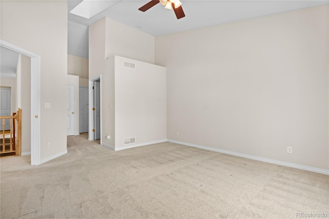 unfurnished bedroom with a towering ceiling, light carpet, and ceiling fan