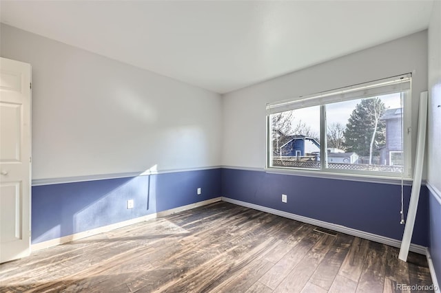 unfurnished room featuring baseboards and wood finished floors