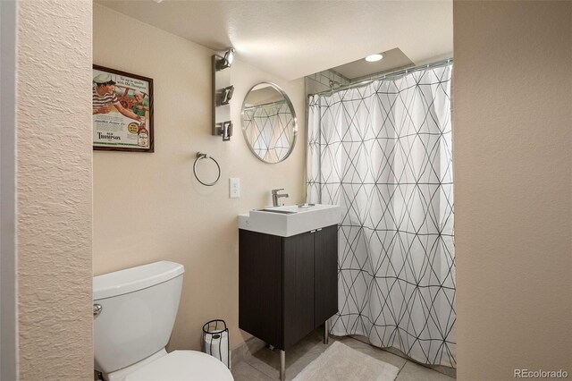 bathroom featuring tile patterned flooring, vanity, a shower with shower curtain, and toilet