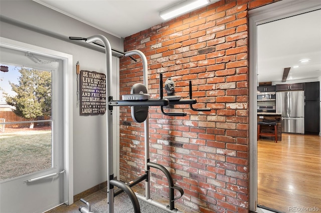 exercise room with a wealth of natural light and brick wall