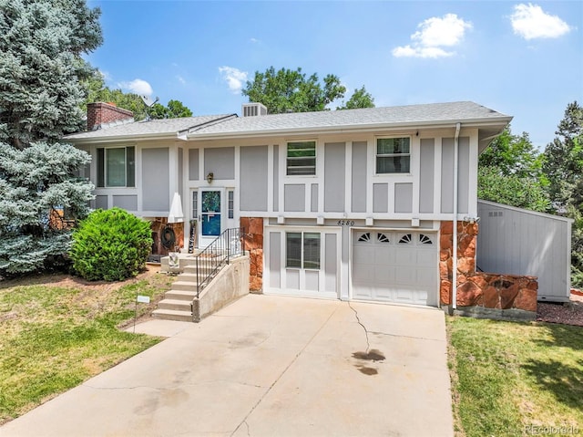 8280 Everett Way, Arvada, CO 80005 - split foyer home with stone siding, concrete driveway, an attached garage, a chimney, and board and batten siding