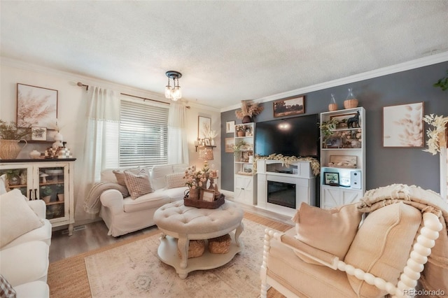 8280 Everett Way, Arvada, CO 80005 - living room featuring crown molding, wood finished floors, a textured ceiling, and a glass covered fireplace