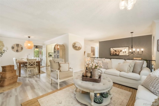 8280 Everett Way, Arvada, CO 80005 - living room featuring a chandelier, light wood-style flooring, and a textured ceiling