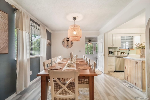 8280 Everett Way, Arvada, CO 80005 - dining space featuring light wood-style flooring, ceiling fan, and crown molding