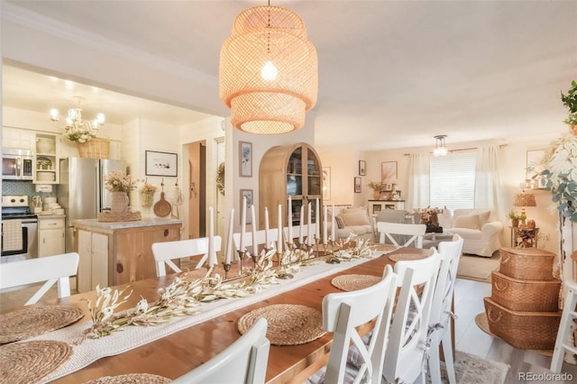 8280 Everett Way, Arvada, CO 80005 - dining area featuring a chandelier, arched walkways, and crown molding