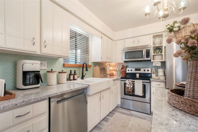 8280 Everett Way, Arvada, CO 80005 - kitchen with appliances with stainless steel finishes, tasteful backsplash, white cabinets, and light wood-type flooring