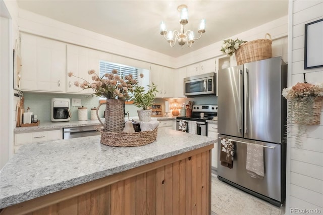 8280 Everett Way, Arvada, CO 80005 - kitchen featuring stainless steel appliances, tasteful backsplash, a chandelier, and white cabinets
