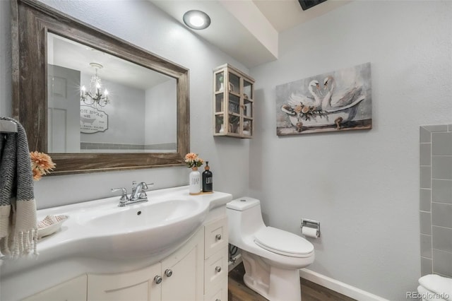 8280 Everett Way, Arvada, CO 80005 - bathroom featuring wood finished floors, vanity, and a chandelier