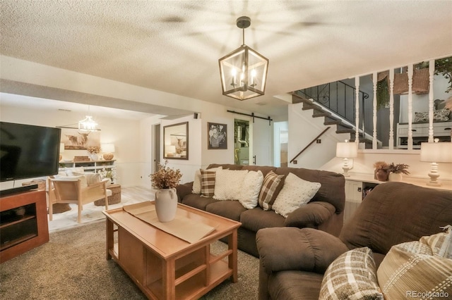 8280 Everett Way, Arvada, CO 80005 - living room with a chandelier, stairs, a barn door, and carpet floors