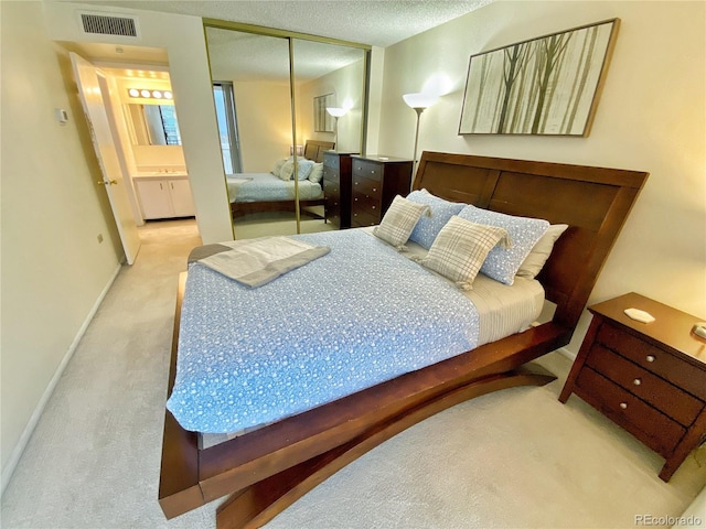 carpeted bedroom featuring a closet and a textured ceiling