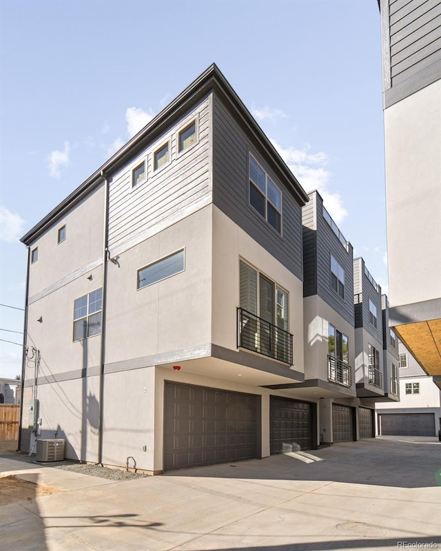 view of property featuring a garage and central AC