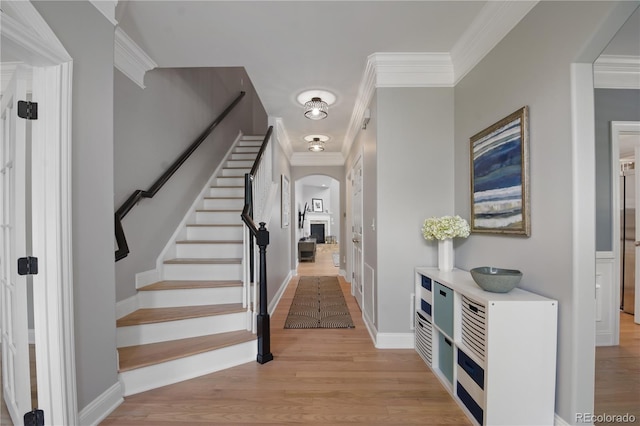 8721 E 23rd Ave, Denver, CO 80238 - foyer featuring arched walkways, light wood finished floors, ornamental molding, stairway, and baseboards