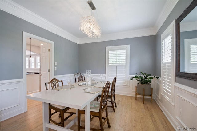 8721 E 23rd Ave, Denver, CO 80238 - dining space with wainscoting, a decorative wall, healthy amount of natural light, crown molding, and a chandelier