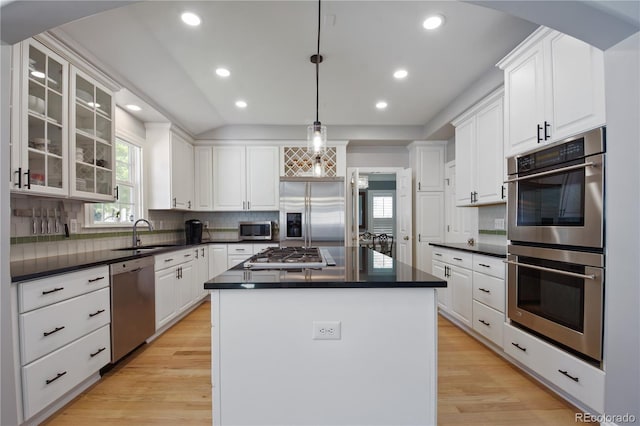 8721 E 23rd Ave, Denver, CO 80238 - kitchen with stainless steel appliances, a sink, dark countertops, a kitchen island, and recessed lighting