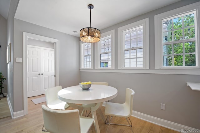 8721 E 23rd Ave, Denver, CO 80238 - dining space featuring plenty of natural light, light wood finished floors, and a chandelier