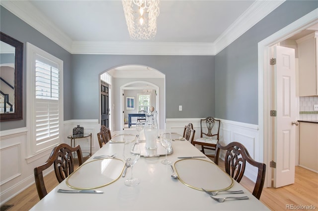 8721 E 23rd Ave, Denver, CO 80238 - dining room with arched walkways, healthy amount of natural light, light wood-type flooring, wainscoting, and ornamental molding