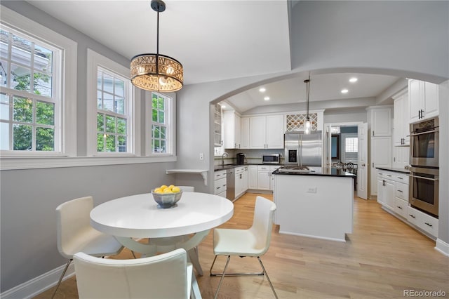 8721 E 23rd Ave, Denver, CO 80238 - dining room with arched walkways, light wood finished floors, a chandelier, recessed lighting, and baseboards