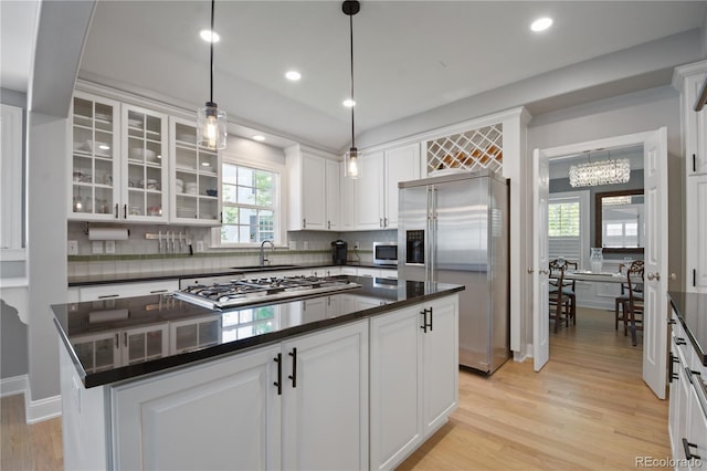 8721 E 23rd Ave, Denver, CO 80238 - kitchen featuring appliances with stainless steel finishes, a sink, dark countertops, white cabinets, and light wood finished floors