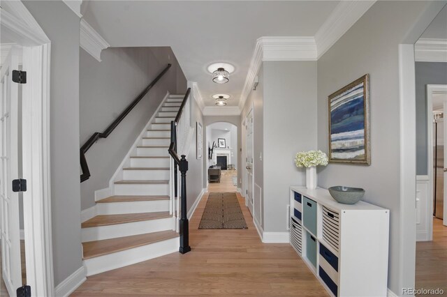 8721 E 23rd Ave, Denver, CO 80238 - foyer entrance with arched walkways, light wood finished floors, crown molding, and stairway