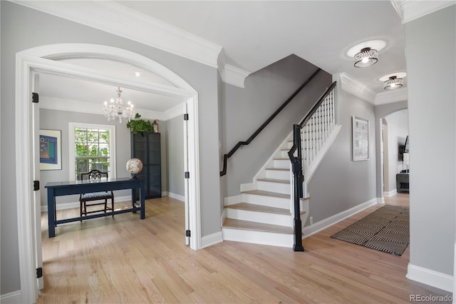 8721 E 23rd Ave, Denver, CO 80238 - entrance foyer with arched walkways, light wood-style flooring, stairs, a chandelier, and crown molding