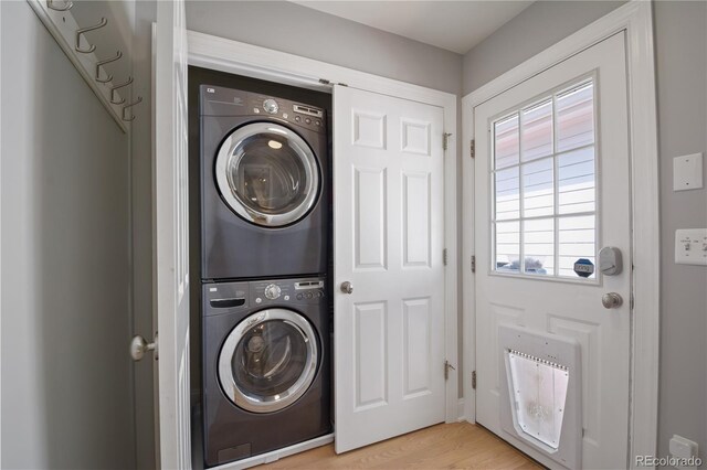 8721 E 23rd Ave, Denver, CO 80238 - laundry area with stacked washer / dryer, heating unit, and light wood-style floors