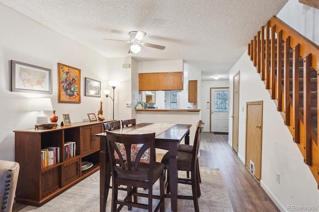 11923 E Ford Dr, Aurora, CO 80012 - dining area featuring wood finished floors, a ceiling fan, stairway, a textured ceiling, and baseboards