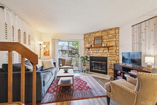 11923 E Ford Dr, Aurora, CO 80012 - living room featuring a textured ceiling, a fireplace, and wood finished floors