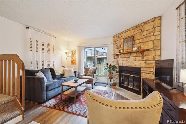 11923 E Ford Dr, Aurora, CO 80012 - living area featuring wood finished floors, a textured ceiling, and a stone fireplace