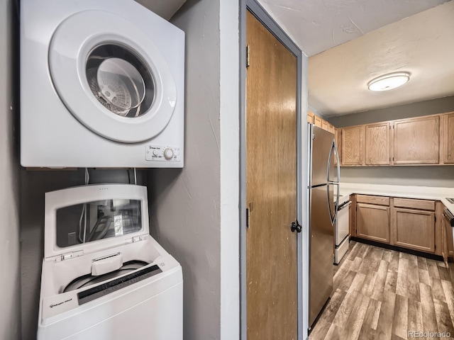 washroom featuring stacked washer / dryer and light wood-type flooring
