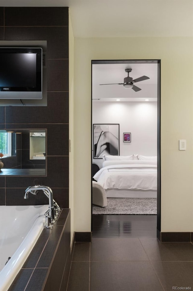 ensuite bathroom featuring baseboards, a ceiling fan, and tile patterned floors