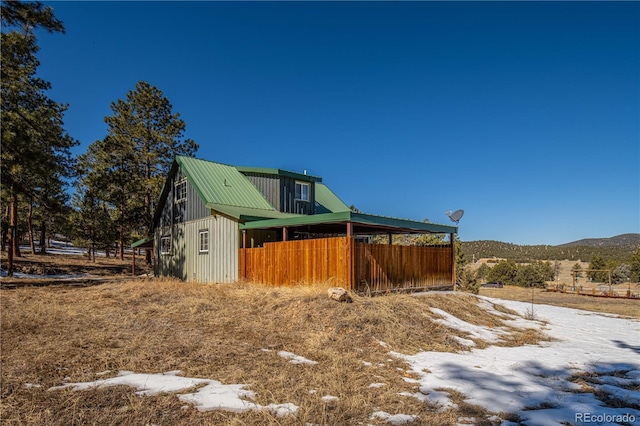 view of home's exterior featuring a mountain view, metal roof, and board and batten siding