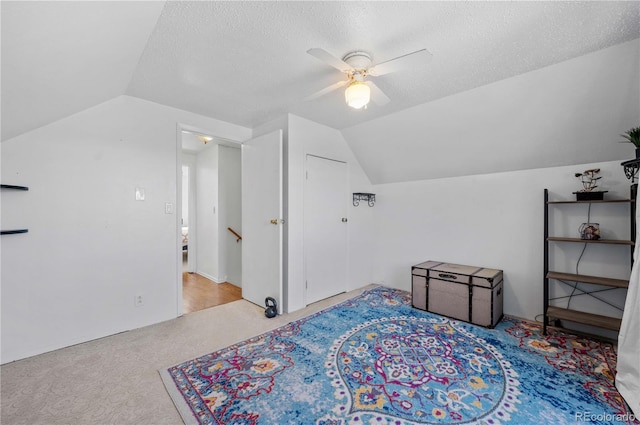 carpeted bedroom featuring a textured ceiling, a ceiling fan, and vaulted ceiling