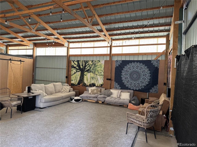 living area featuring a barn door and metal wall