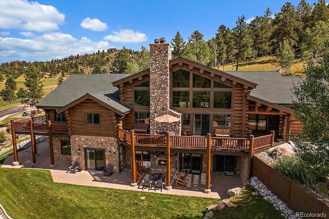 rear view of property with a patio, a yard, and log siding