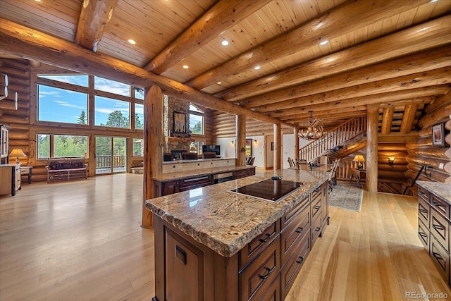 kitchen with light wood-style floors, beam ceiling, log walls, and black electric cooktop