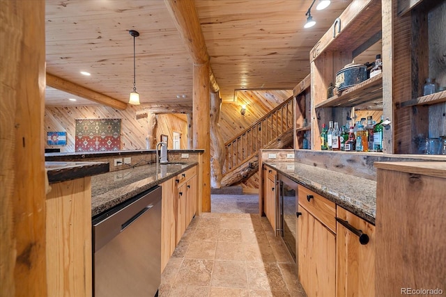 interior space featuring dishwasher, a bar, wood walls, and a sink