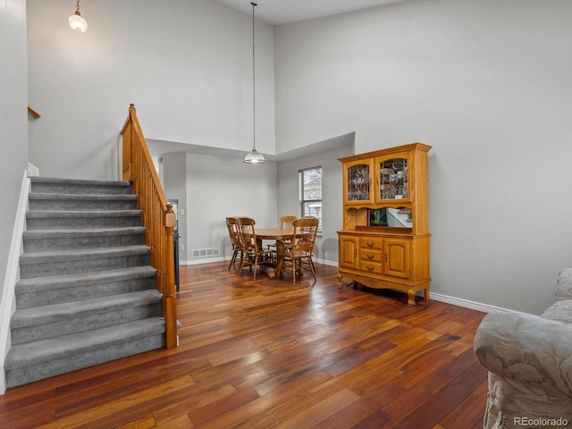 dining room with dark hardwood / wood-style floors and a high ceiling