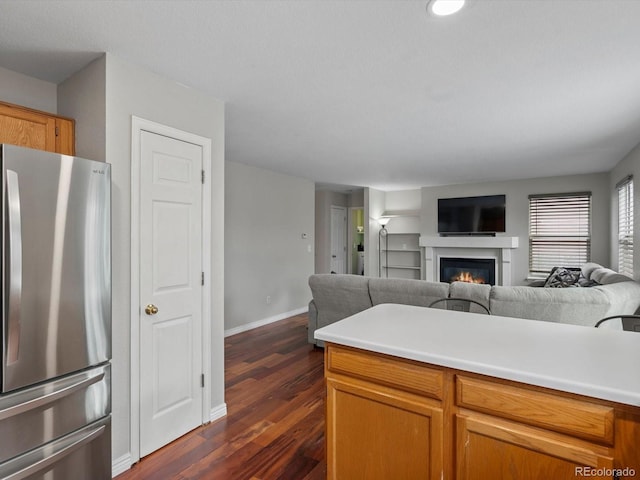 kitchen with dark wood-type flooring and stainless steel refrigerator