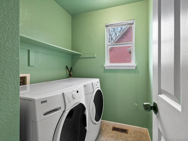 laundry area featuring light tile patterned flooring and washing machine and clothes dryer