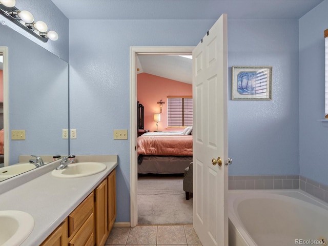 bathroom featuring tile patterned flooring, vanity, vaulted ceiling, and a bath