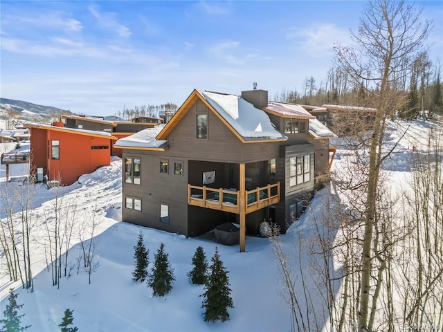 snow covered house with a wooden deck