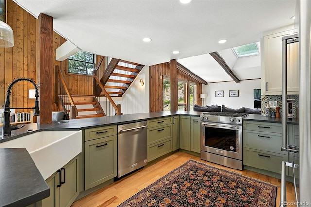 7221 S Brook Forest Rd, Evergreen, CO 80439 - kitchen featuring green cabinets, stainless steel appliances, lofted ceiling, dark countertops, and a skylight