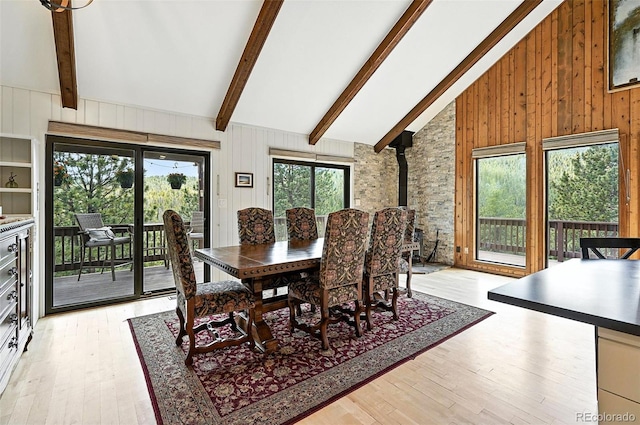 7221 S Brook Forest Rd, Evergreen, CO 80439 - dining area featuring wood walls, light wood-style flooring, and a wood stove